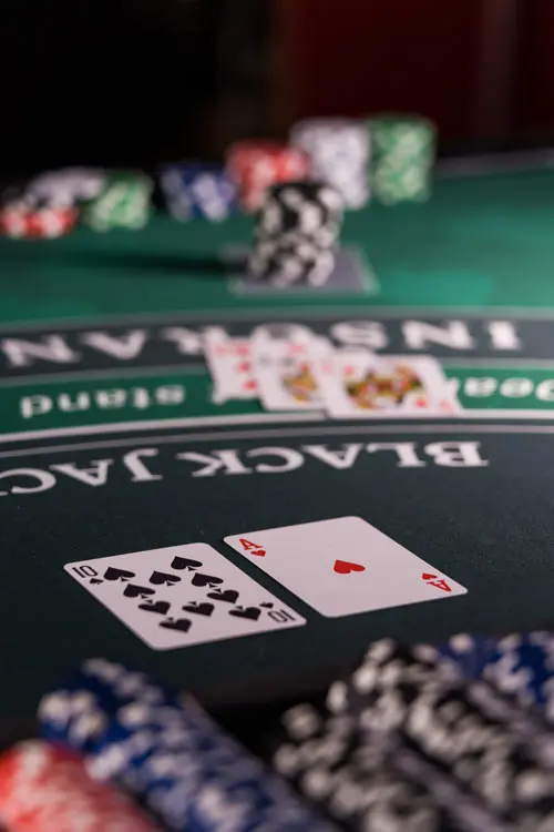 Una mesa de blackjack con las cartas repartidas y las fichas apiladas