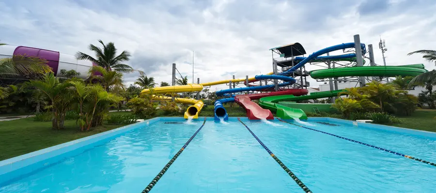 Toboganes de colores y la piscina de un parque acuático entre palmeras