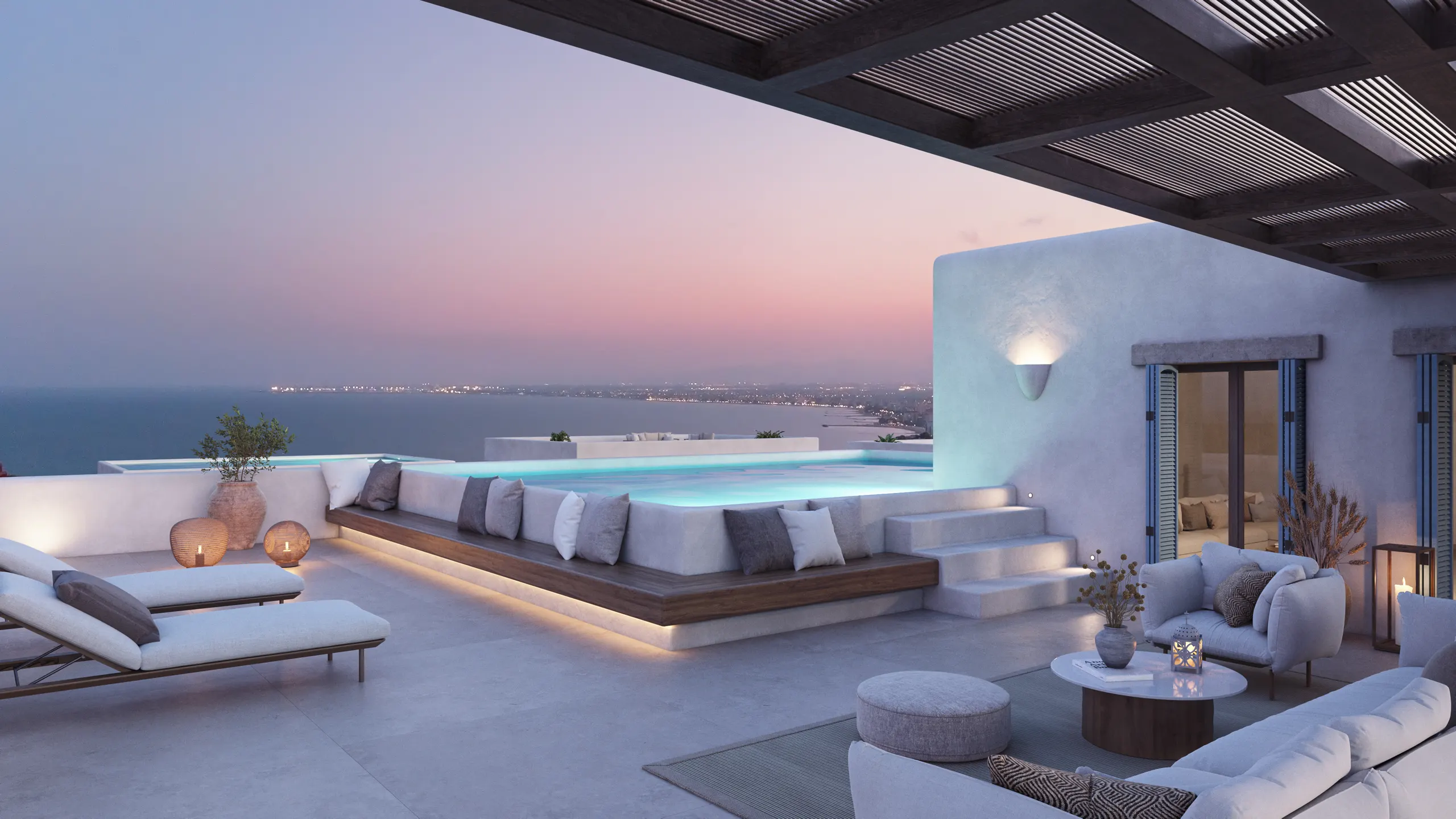 Terrasse eines Penthouses im Dorf in der Abenddämmerung, mit dem Pool und dem Meer im Hintergrund