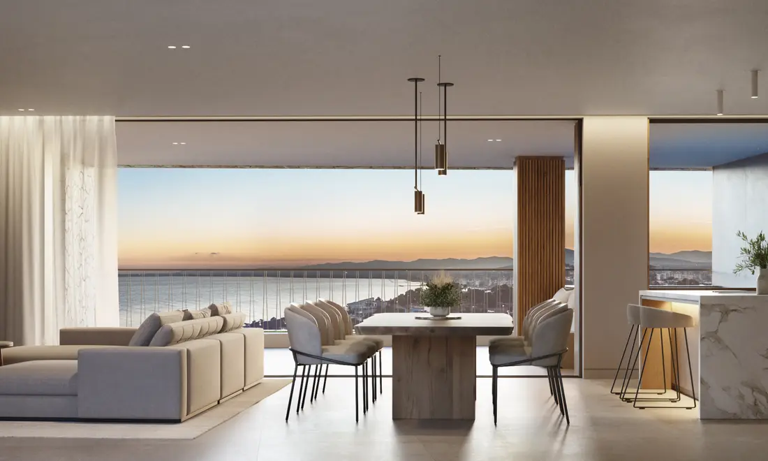 Salón comedor de una vivienda tipo al atardecer, con vistas a la costa