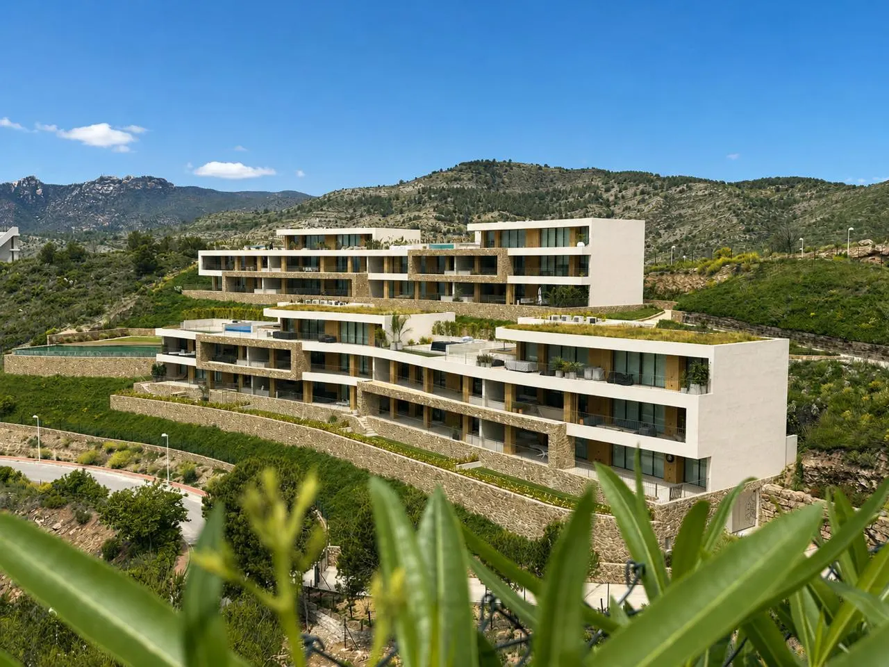 Fotografía de Andryala ya construida, con sus dos bloques escalonados en la ladera de La Colomera y las montañas al fondo