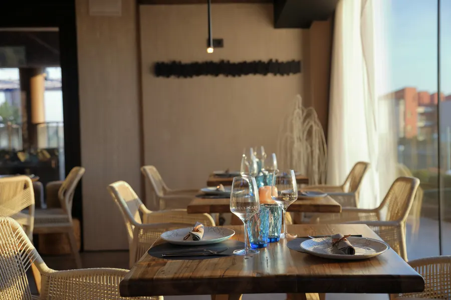 Dækket bord i restauranten ved vinduespartiet, med glassene sat frem