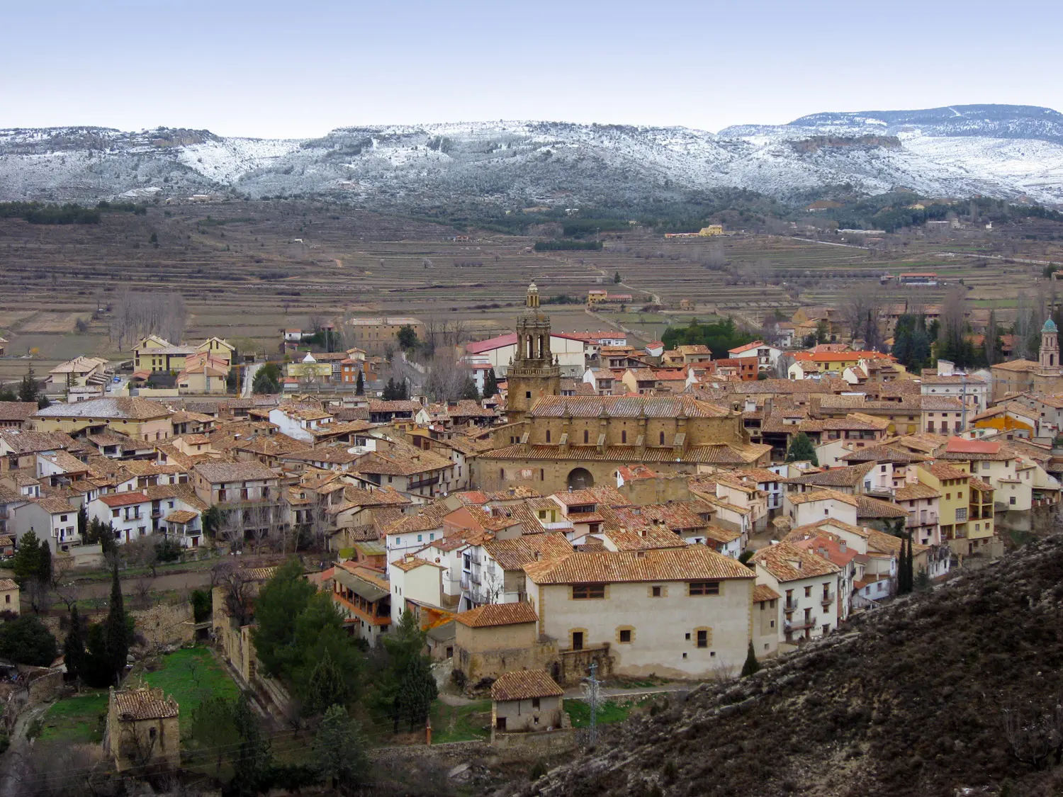 Mora de Rubielos con sus tejados de teja y las montañas nevadas al fondo