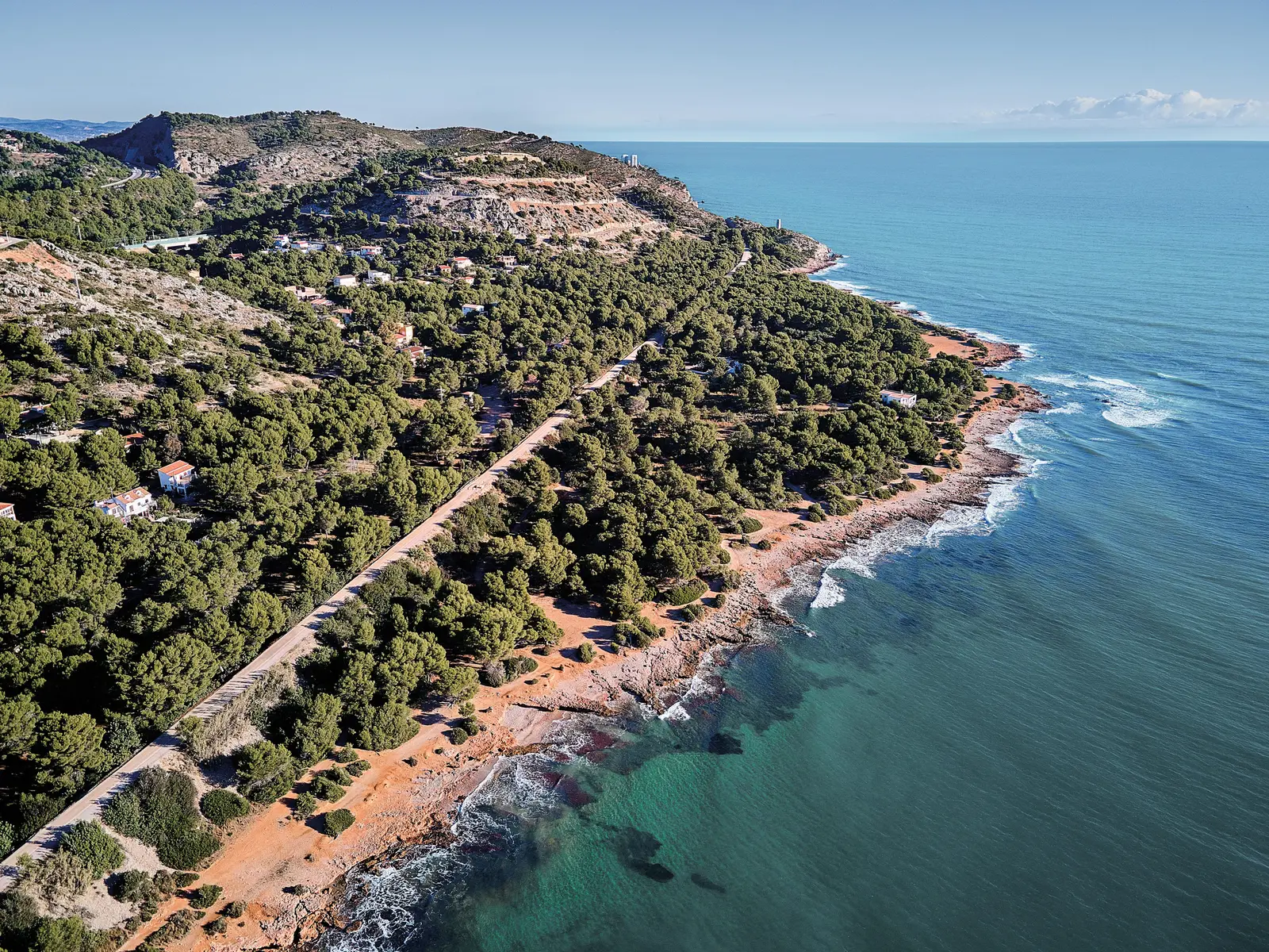 La Vía Verde recorriendo la costa entre pinos, con las calas rocosas y el agua turquesa